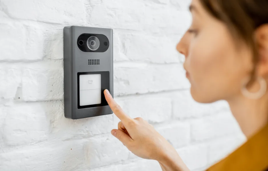 Visitor using a keypad intercom system at a modern NYC building entrance