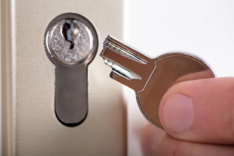 A worn brass house key with smoothed-down teeth that no longer aligns the lock pins.