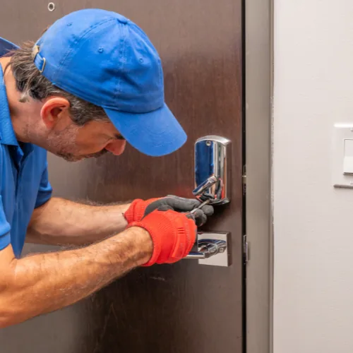 Locksmith technician changing an apartment door lock for a new NYC renter