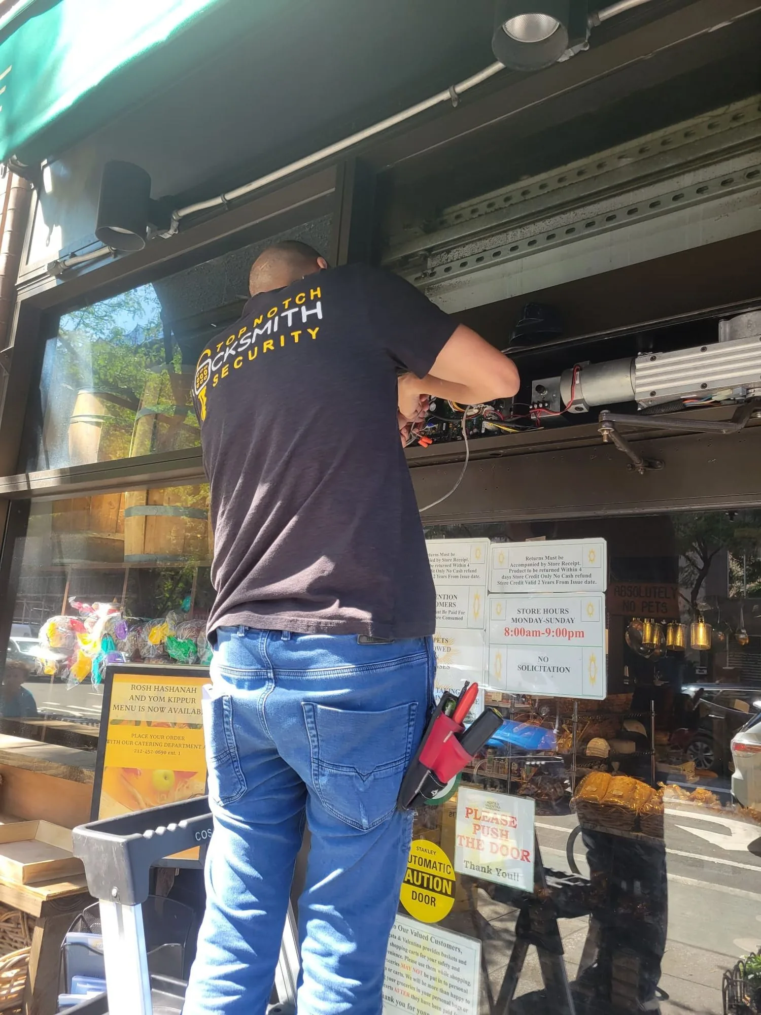 Top Notch Locksmith & Security technician servicing an automatic storefront door in New York City
