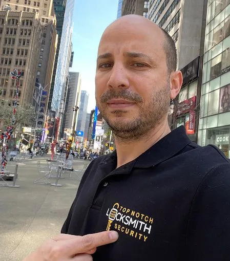 Roye, founder of Top Notch Locksmith & Security NYC, in Midtown Manhattan wearing the company's branded polo